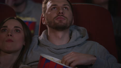 Close-up-view-of-young-people-faces-watching-movie