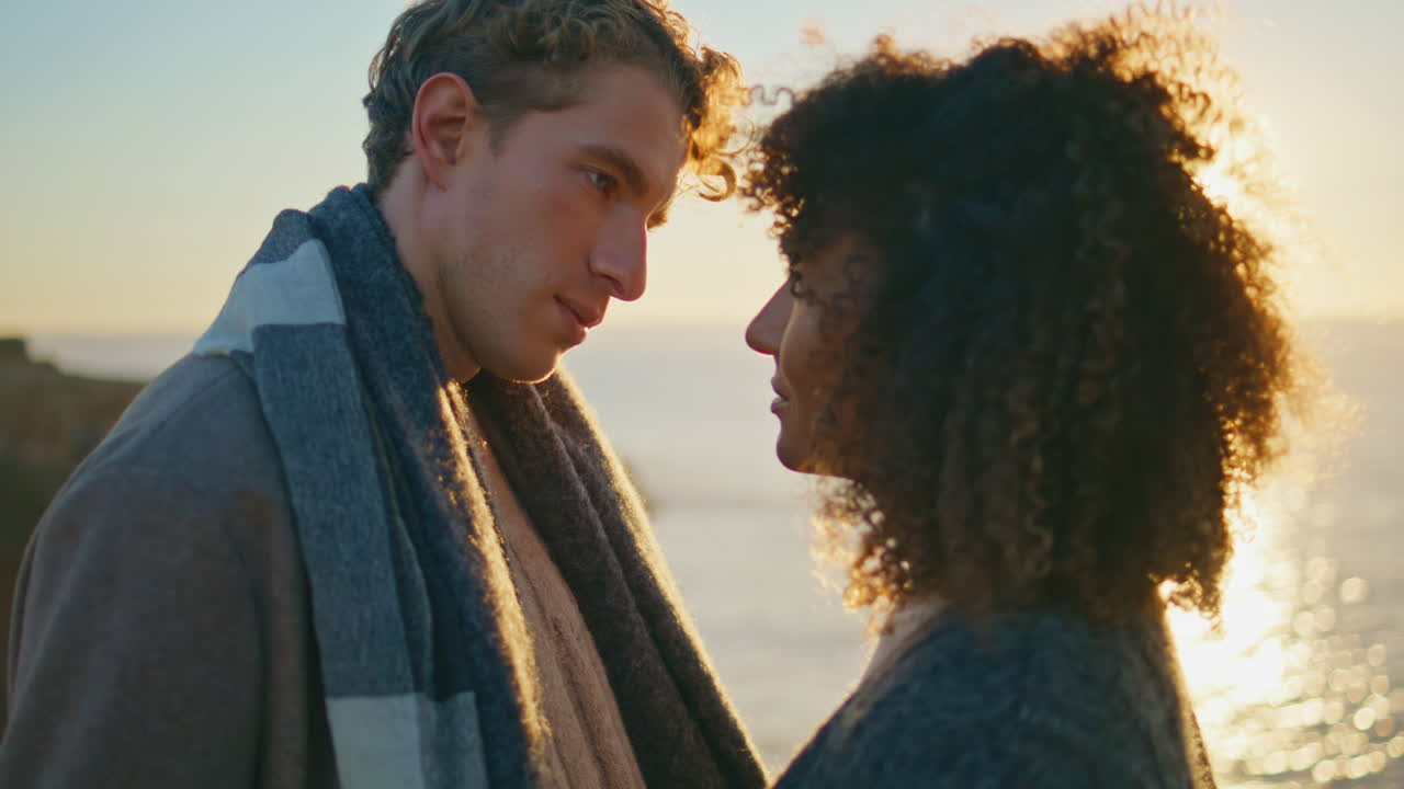 Romantic sunset sweethearts date closeup. Ethnic lovers enjoy intimacy at ocean