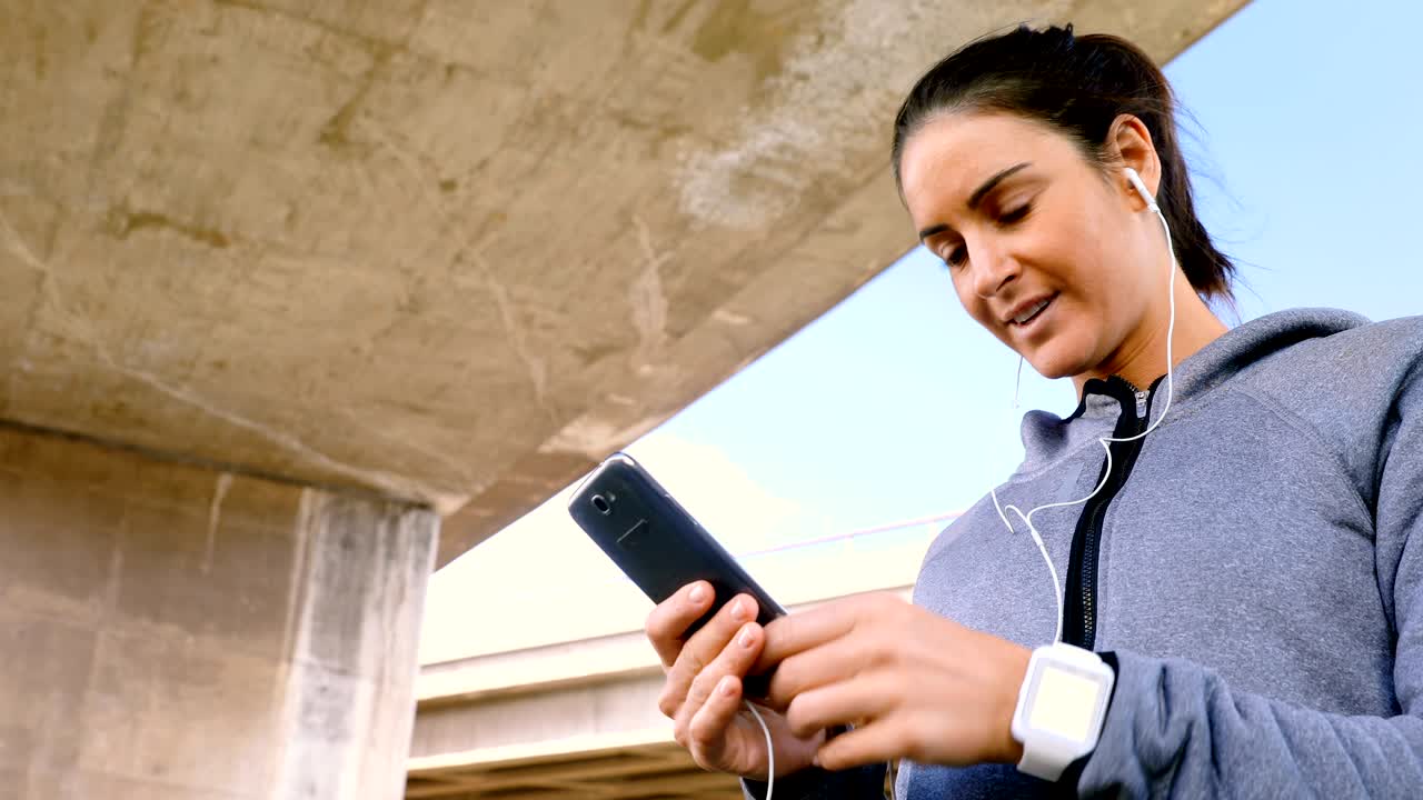 mujer escuchando música en el teléfono móvil mientras corre 4k