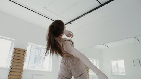 a young woman practicing yoga and ballet in a studio.