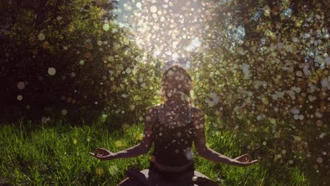 animation of light spots over caucasian woman practicing yoga and meditating