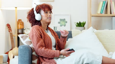 woman relaxing at home with headphones and smartphone