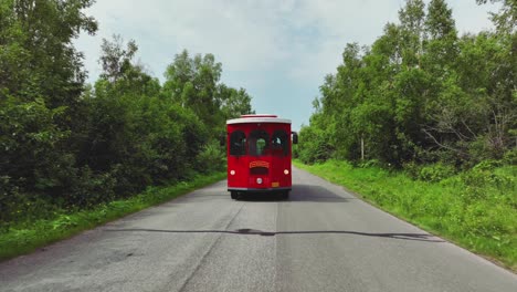 front view of a red trolley bus touring scenic landscape of anchorage in alaska