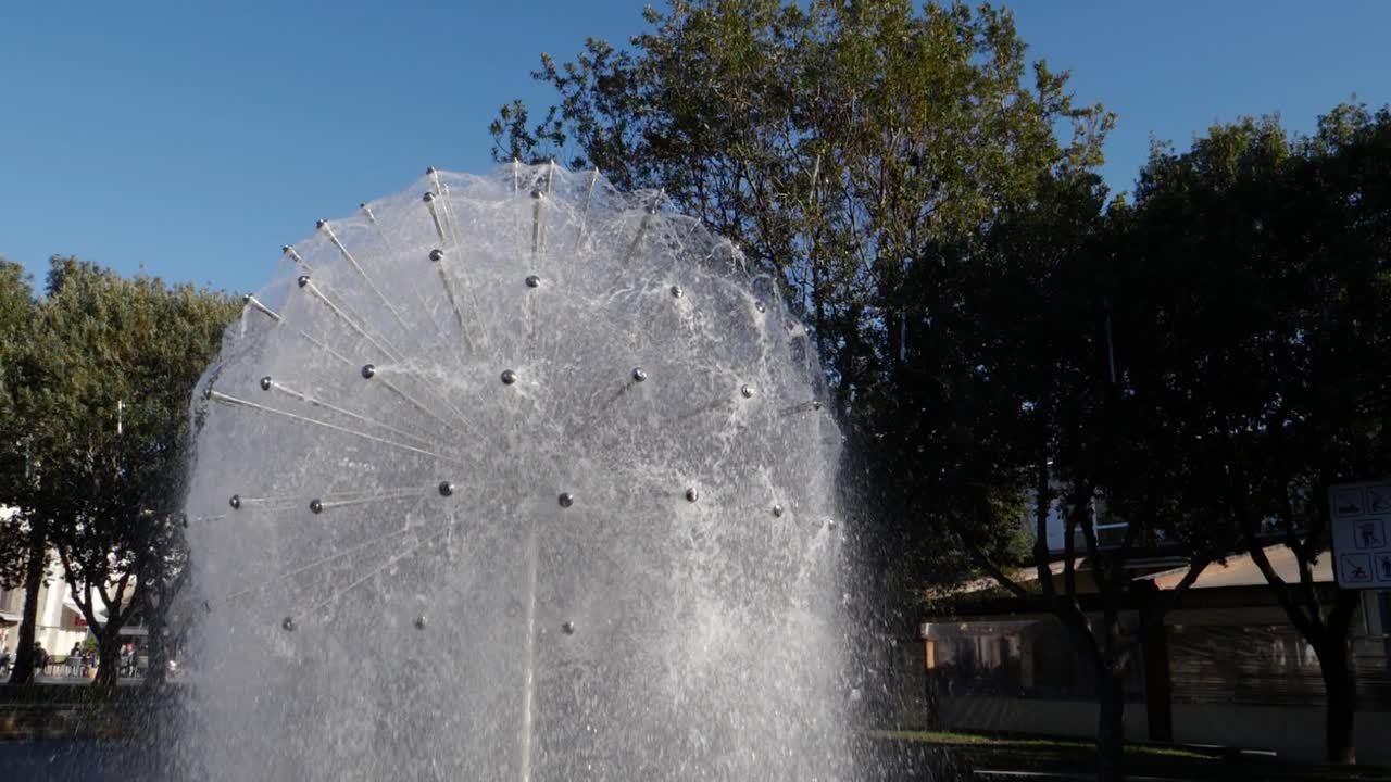 girando lentamente alrededor de una fuente de agua con forma de diente de león en el parque hlavaty en koper, eslovenia