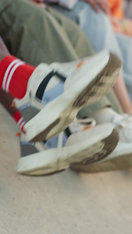 closeup of stylish sneakers and socks on people sitting