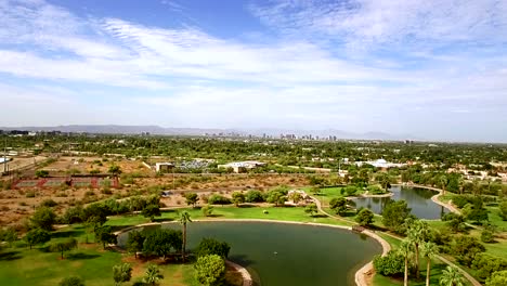 aerial pull back from phoenix skyline to the water features at granada park, ​north phoenix, arizona