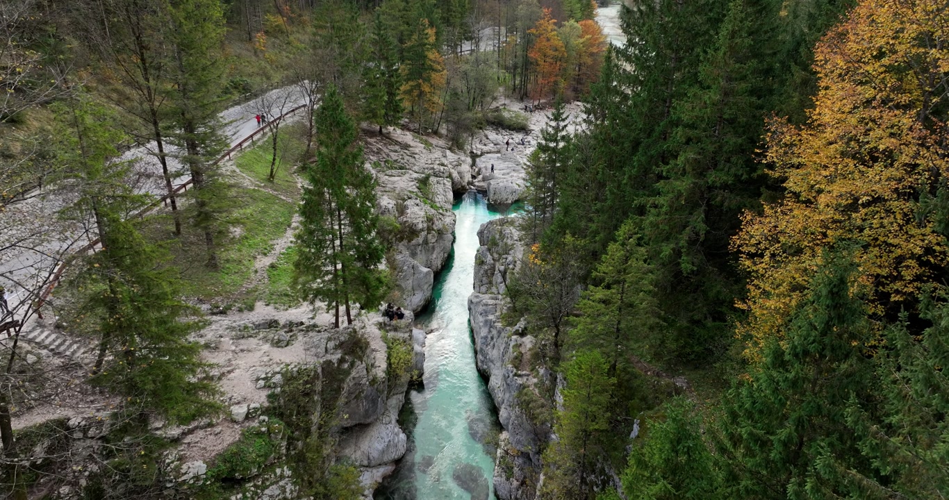 Aerial: alpine Soca River during the day in Bovec, Slovenia, establishing drone shot