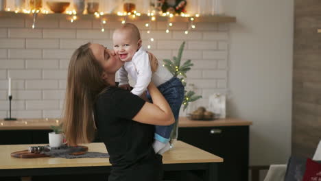 Joven-Madre-Sosteniendo-A-Su-Hijo-Recién-Nacido-A-Cámara-Lenta.-Familia-En-Casa,-Mamá-Y-Bebé,-Para-Navidad