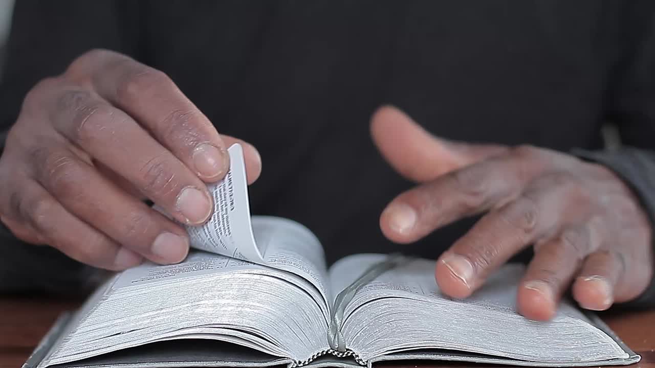 Preghiera con le mani giunte e Bibbia sul tavolo con persone, video stock