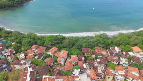 drone pan right showing colorful rooftops and beach of las catalinas town in costa rica