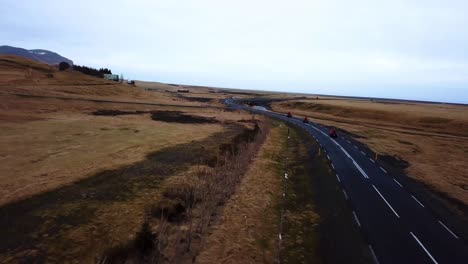 Vista-Aérea-De-Quads-Rojos-Acelerando-En-Una-Carretera-Vacía-A-Través-De-Las-Tierras-Altas-De-Islandia