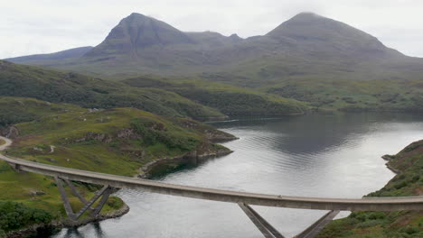 cinematic drone shot of the kylesku bridge in north-west scotland that crosses the loch a' chàirn bhàin in sutherland