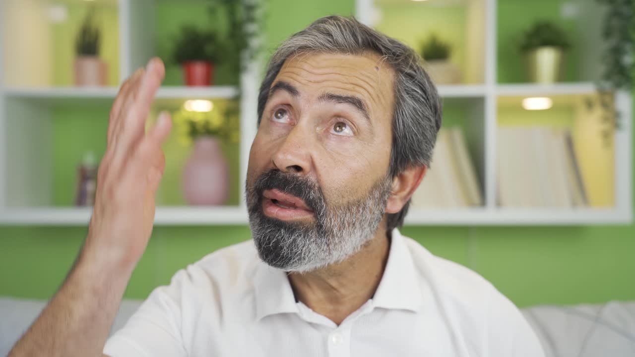 hombre maduro en primer plano hablando mirando a la cámara deprimido.