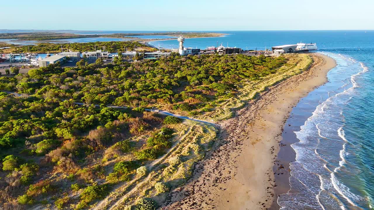 Drone footage captures the scenic coastline of Bellarine Peninsula with lush greenery and a serene beach under clear skies