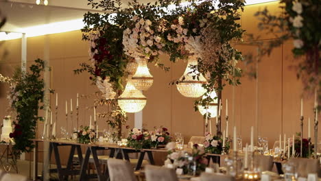 wedding reception tables with chandelier and hanging flower decor