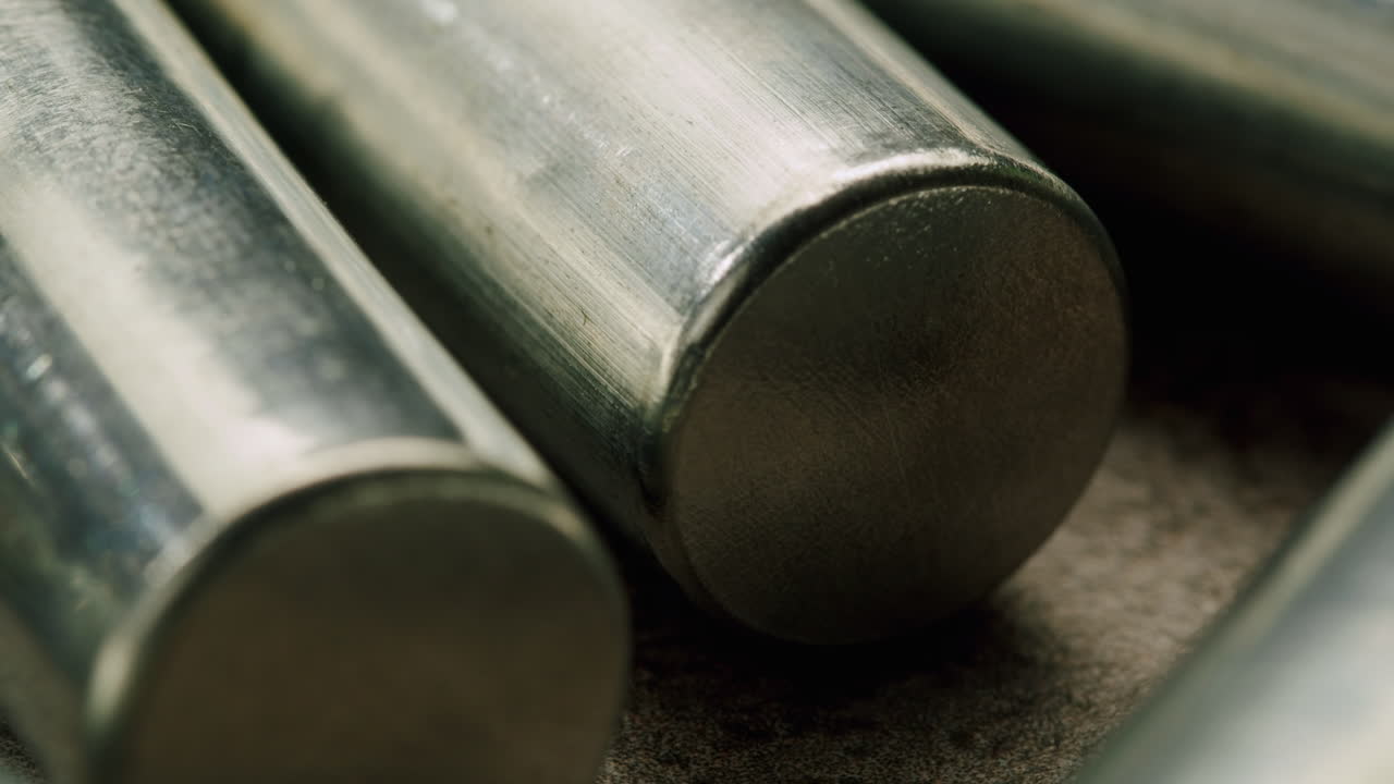 Silver batteries AA and AAA on black background close-up. Double-A battery is a standard size single cell cylindrical dry battery. Batteries are common in portable electronic devices. An AA battery is composed of a single electrochemical cell that may be either a primary battery or a rechargeable ba