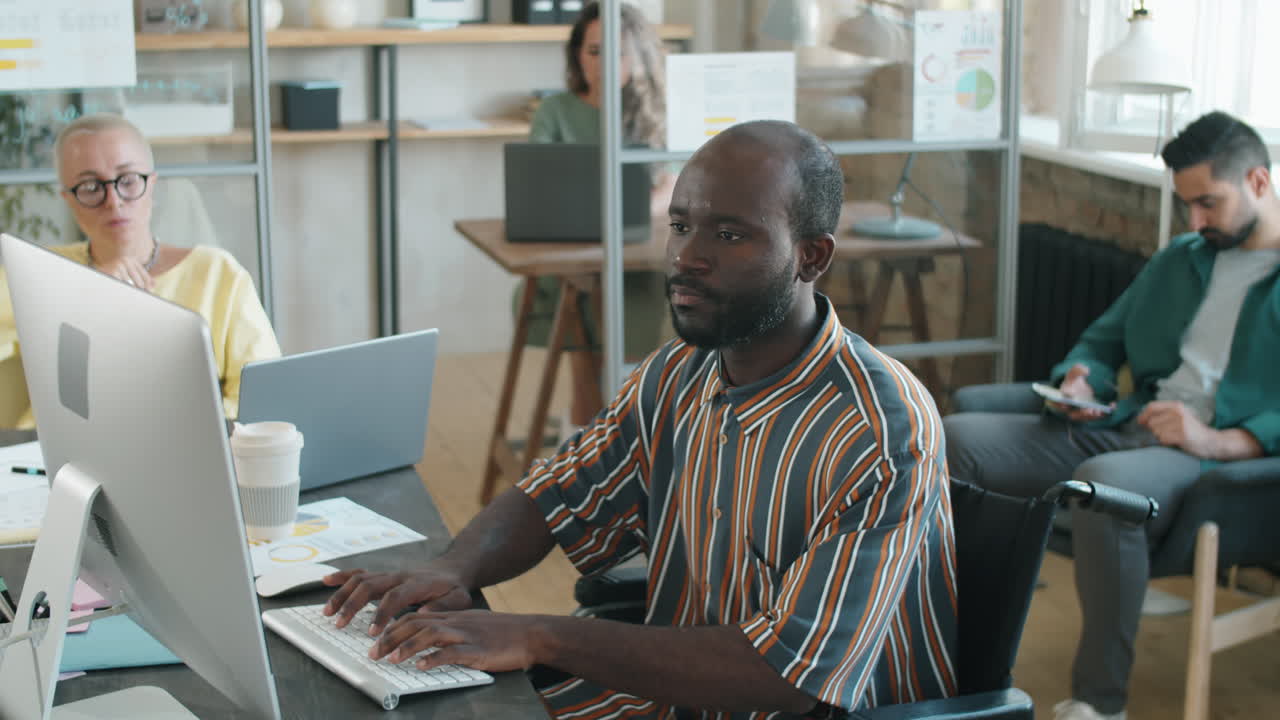Black Businessman with Disability Typing on Computer in Office