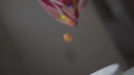 pouring candy from candy bag into white bowl