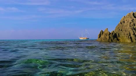 sea water surface perspective of sailing ship on the horizon between rocks