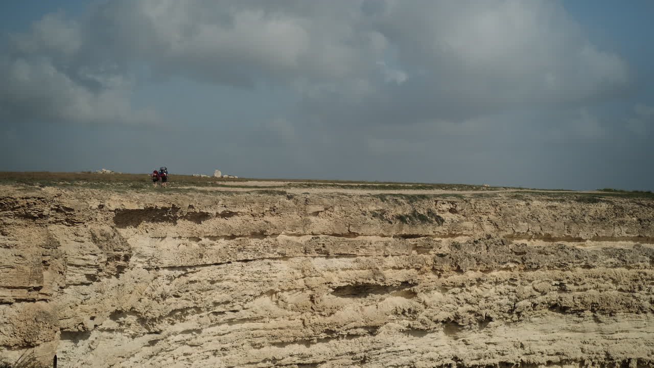 Escursionisti su un sentiero in cima a una scogliera
