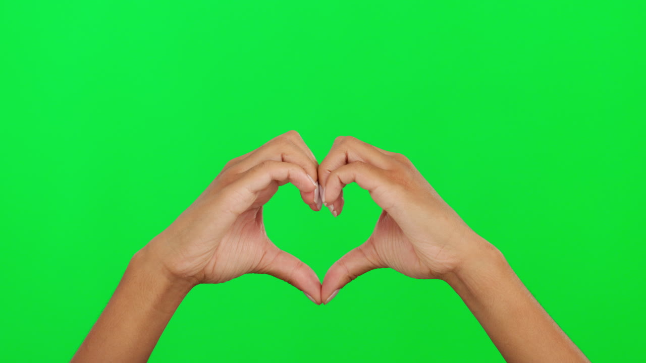 corazón, forma y manos de una persona en la pantalla verde