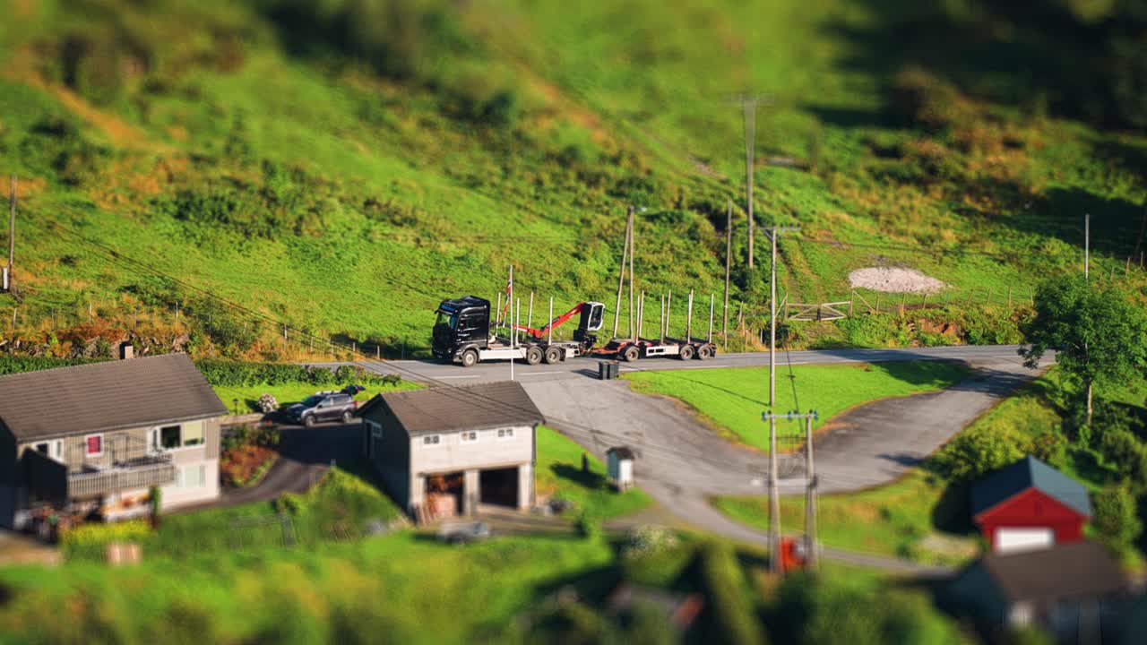 노르웨이 의 작은 해안 마을 을 가로지르는 은 길 을 따라 나무 트레일러 가 언덕 을 올라간다