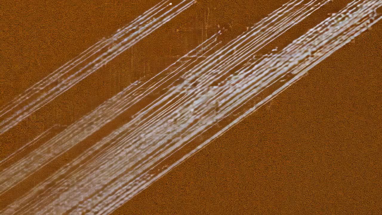 Frames showing diagonal band growing and brightening across mottled brown ground, with streaks