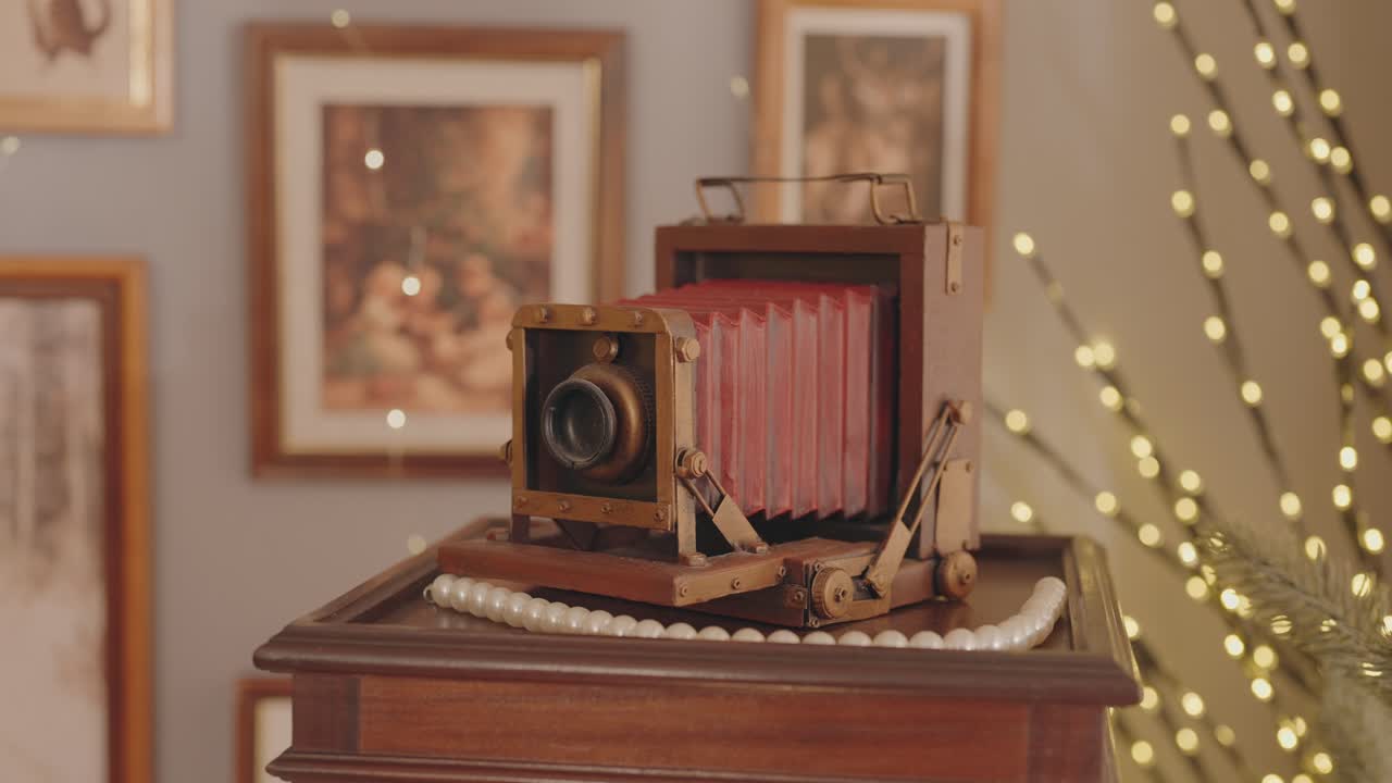부드럽게 빛나는 조명이 있는 나무 받침대 위의 앤티크 벨로우즈 카메라