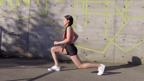 Young-Hispanic-woman-doing-lunges-for-outdoor-exercise,-Side-View