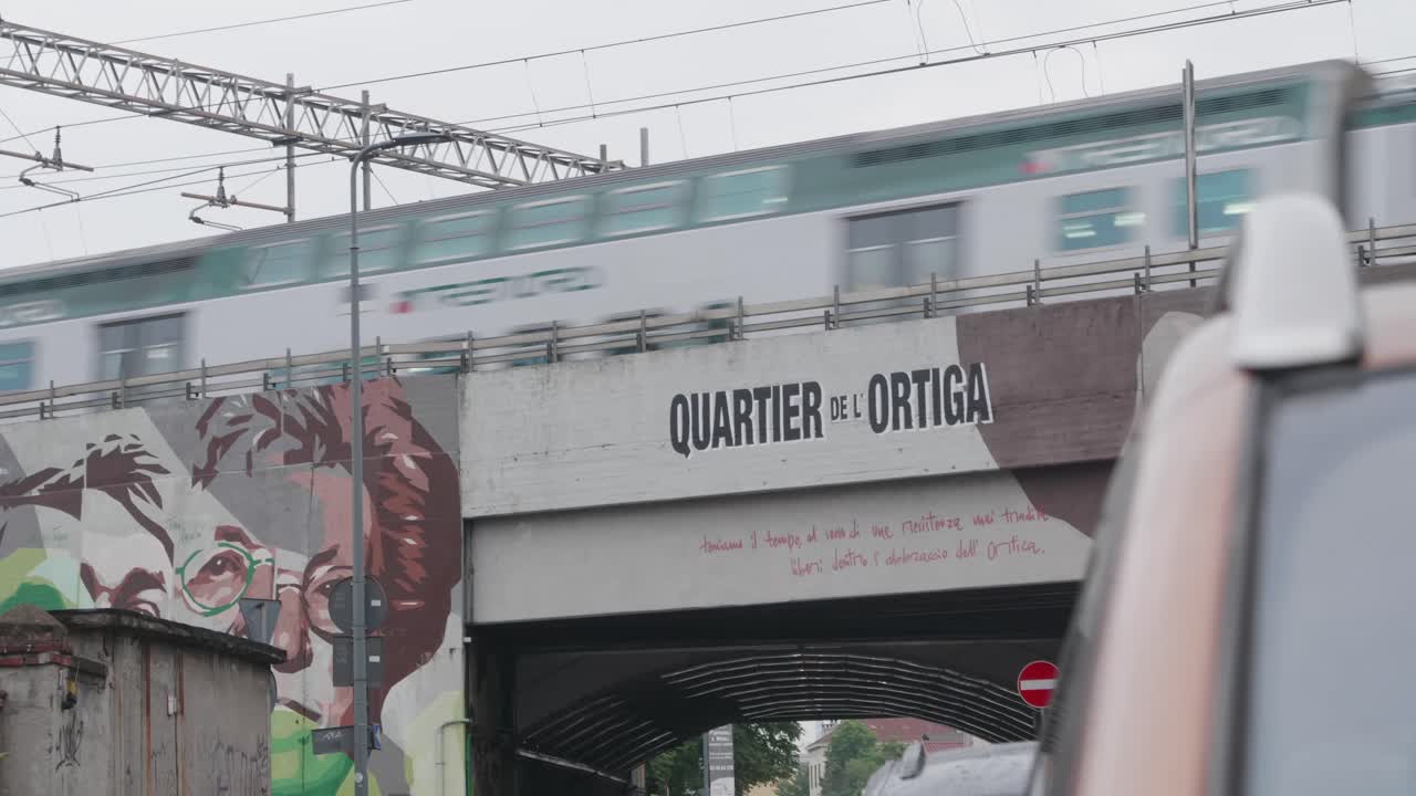 tren pasando por un puente decorado con grafitis, suburbios de la ciudad de milán