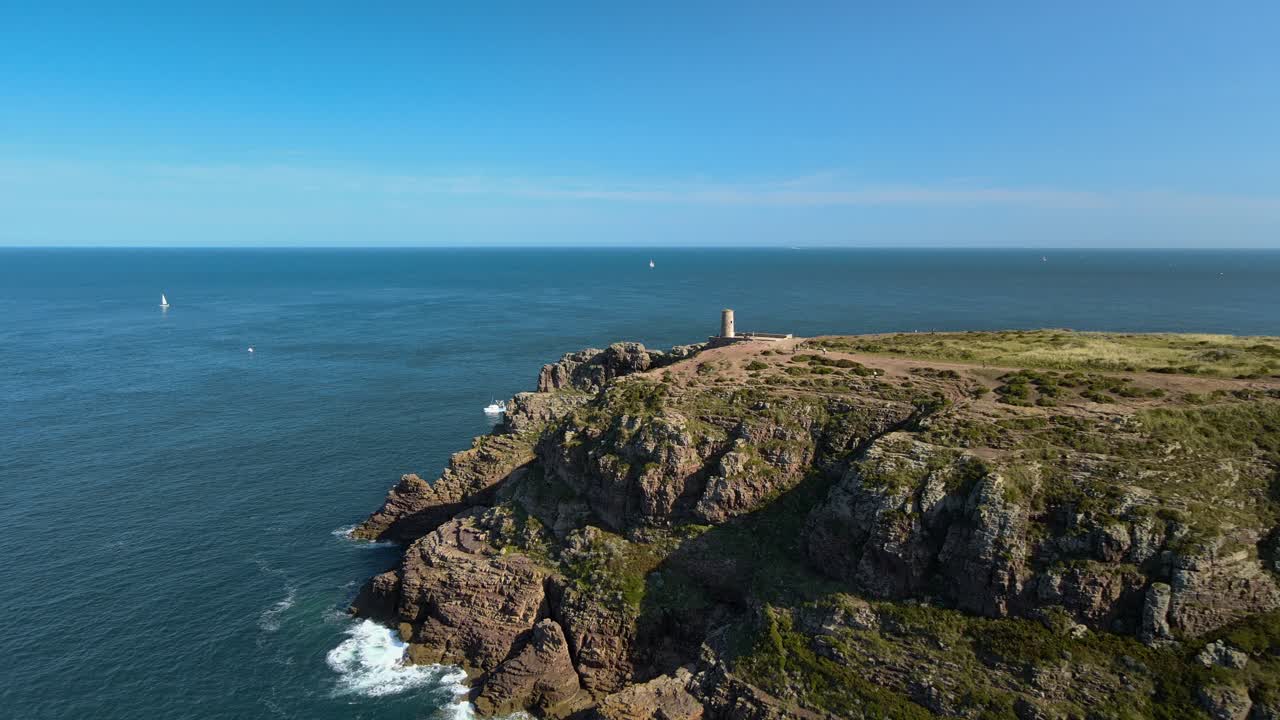 Vue aérienne de falaises maritimes escarpées et d'un océan scintillant, paysage côtier spectaculaire avec d'imposantes formations rocheuses et des eaux turquoise, séquences cinématographiques 4K par drone pour contenu de voyage et de nature.