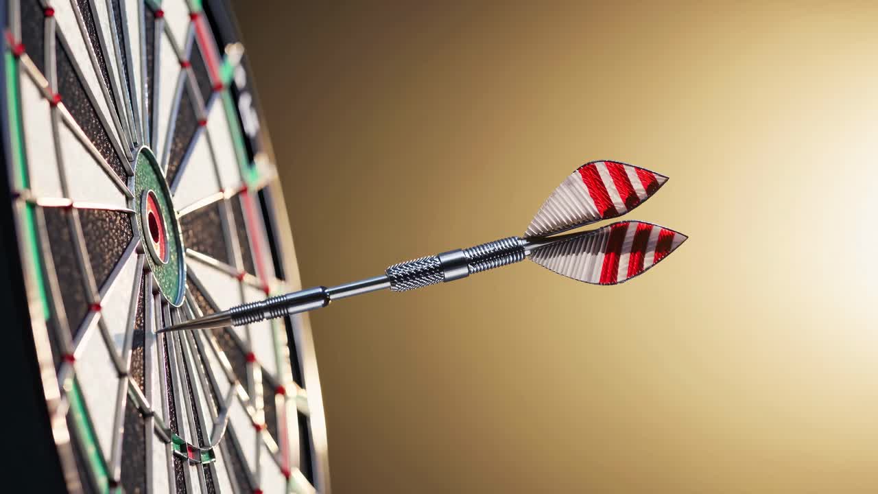 Close-up, side angle of a dart hitting the bullseye on a dartboard