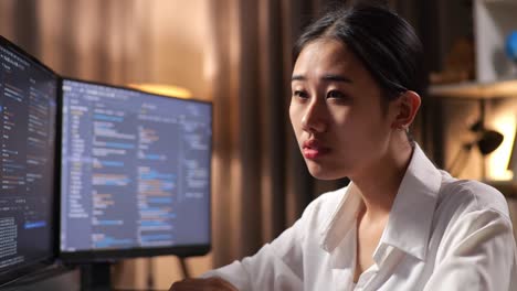 close up of asian woman programmer yawning while creating innovative software engineer developing app, program, video game on desktop computer at home. terminal with coding language