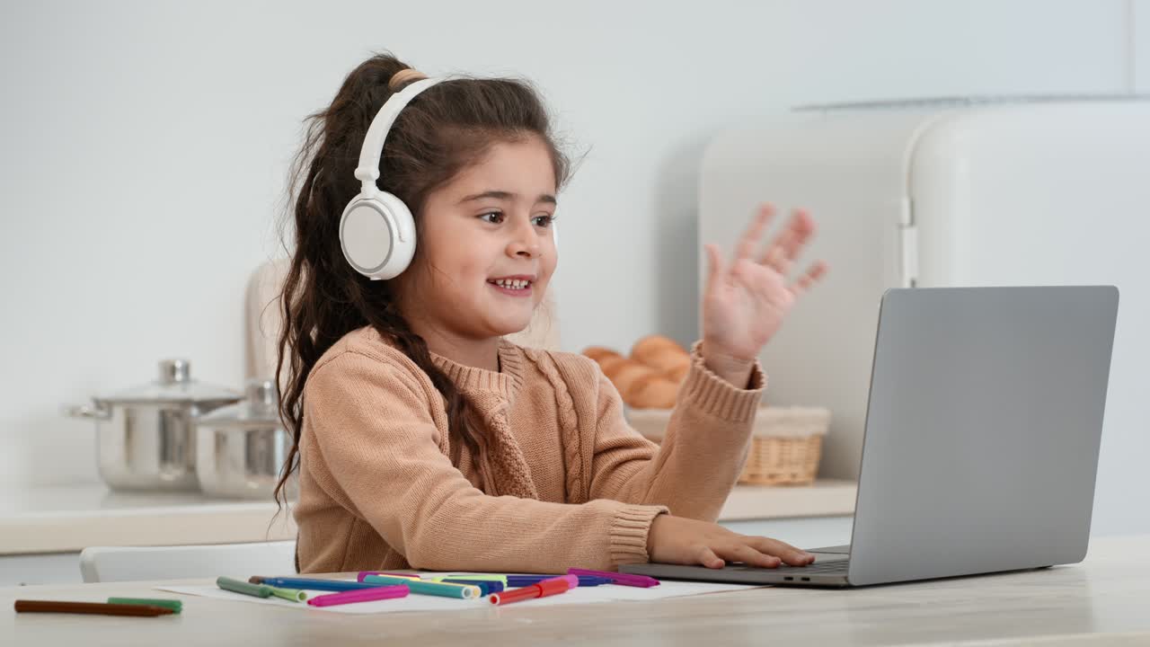 niña haciendo una llamada de video usando una computadora portátil sentada en casa
