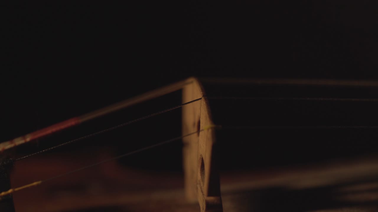 古小提琴的近景, 樂器上的劇烈光線變化, 經典交響曲音樂視頻片段