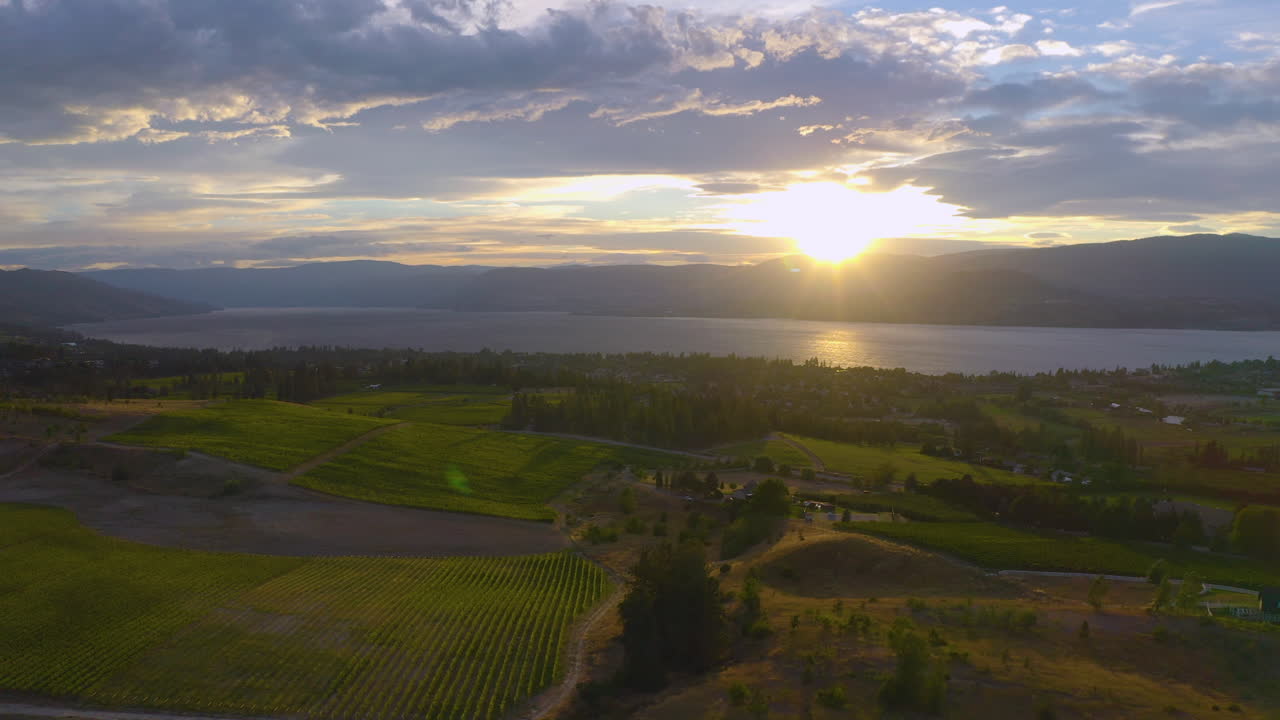 Vista aerea dei vigneti di Kelowna al tramonto del sole sulle montagne, attraverso il lago Okanagan