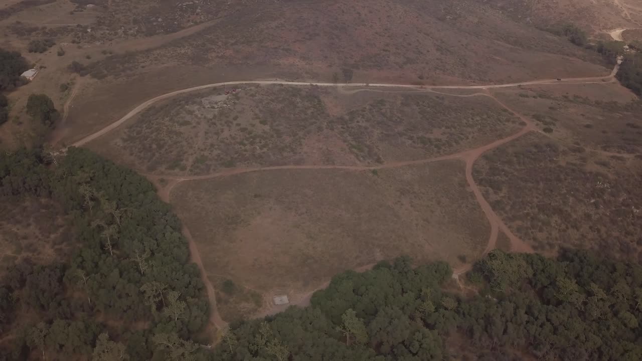 vista de un avión no tripulado volando en círculos que muestra una montaña con dos carreteras cerca de un bosque en méxico