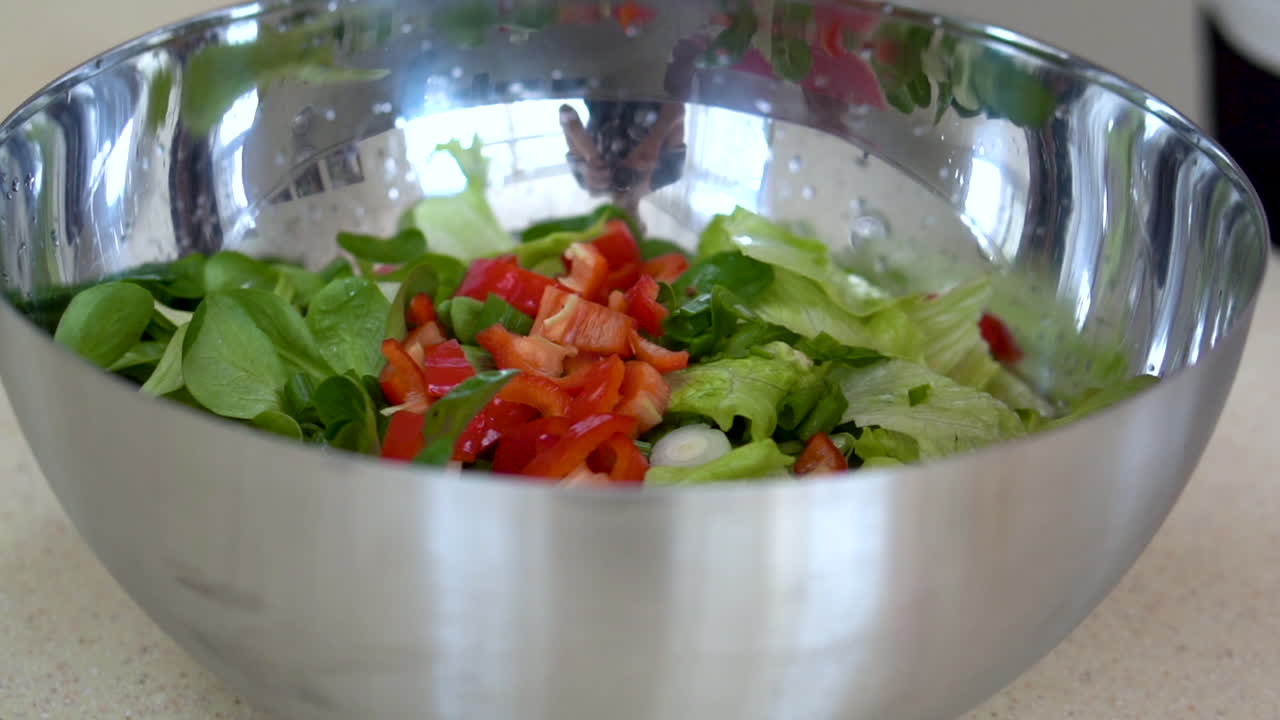Making a fresh salad with red bell pepper and lettuce