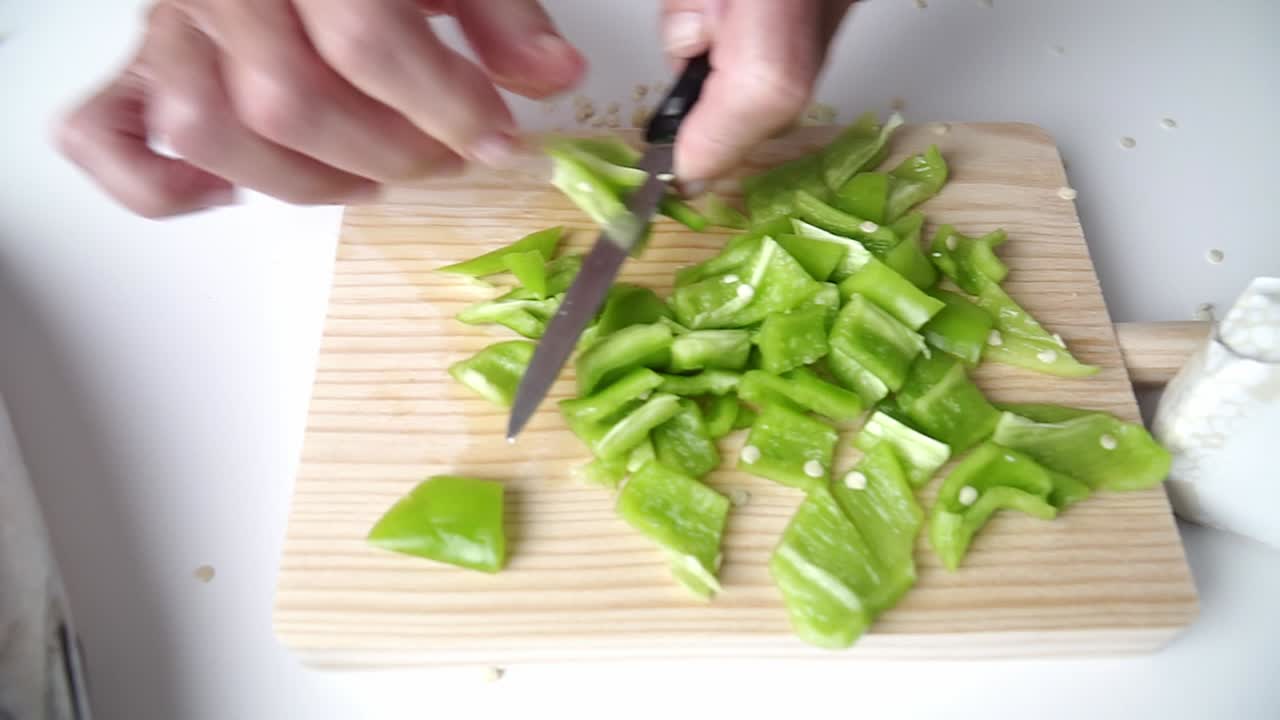 늙은 손을 가진 백인 사람은 나무 판자에 피망을 자르고, 비행기 한쪽에 생선을