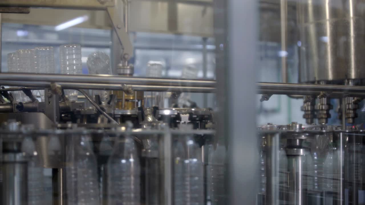 Bottling conveyor product line for pouring beverages into plastic bottles. Robotics lines instead of human labor