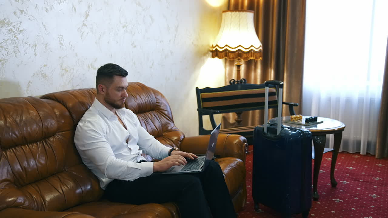 Businessman working in hotel. Young businessman working with laptop in hotel room