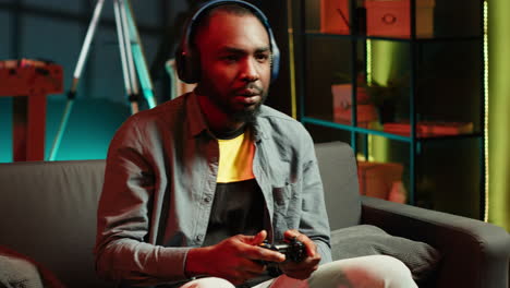 cheerful man wearing headphones, celebrating after victory in videogame