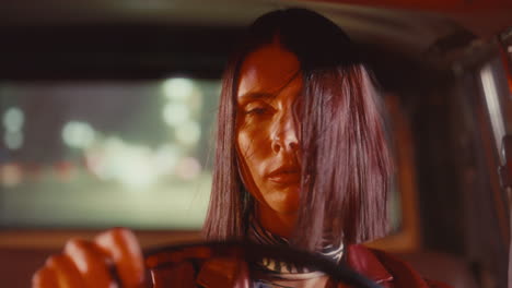 portrait of attractive woman with hair blowing across face driving at night