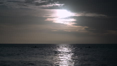 people paddleboarding on the sea at sunset on their sups near tanjung aru beach, kota kinabalu, malaysia