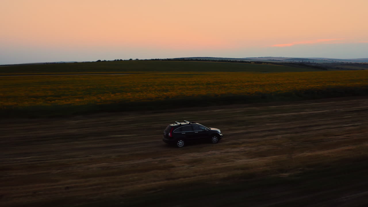todoterreno todoterreno cerca de los campos de girasoles por la noche, coche de seguimiento de drones