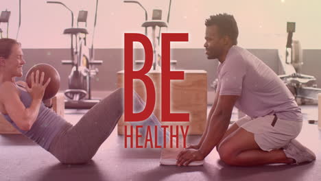 animation of be healthy text over diverse man and woman exercising in gym