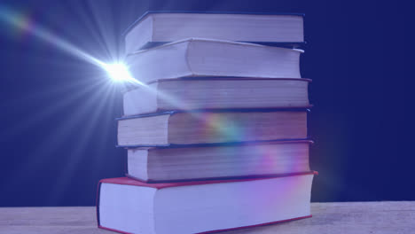 animation of glowing light over stack of books on blue background