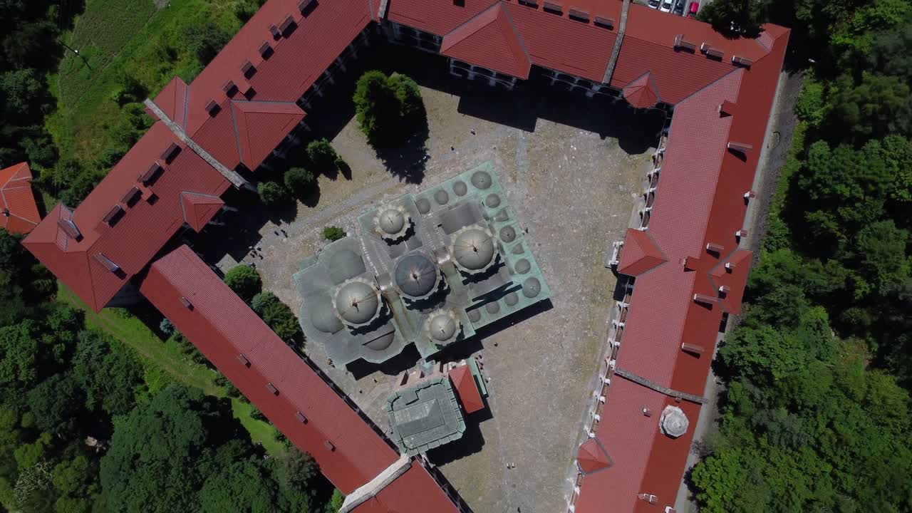 Drone ascending above and looking down onto Rila Monastery, Bulgaria