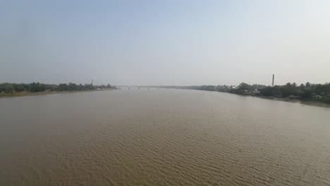 ultra wide cinematic shot of a calm muddy river during daytime in bengal, india