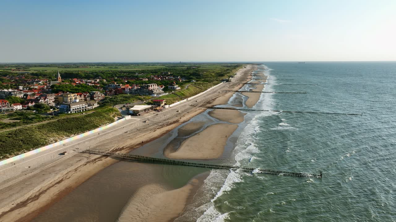 hermosa fotografía aérea de una playa en una zona rural, con muslos de madera para evitar la erosión, en un día de verano sin nubes